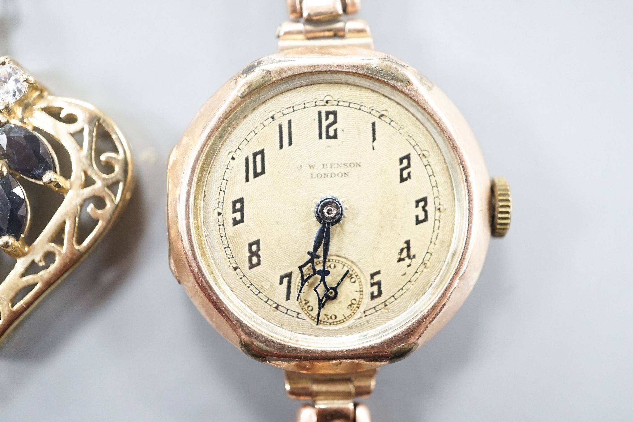 A lady's early 20th century 9ct gold manual wind wrist watch, on a 9ct strap(a.f.), gross weight 21.2 grams and a costume pendant on chain.